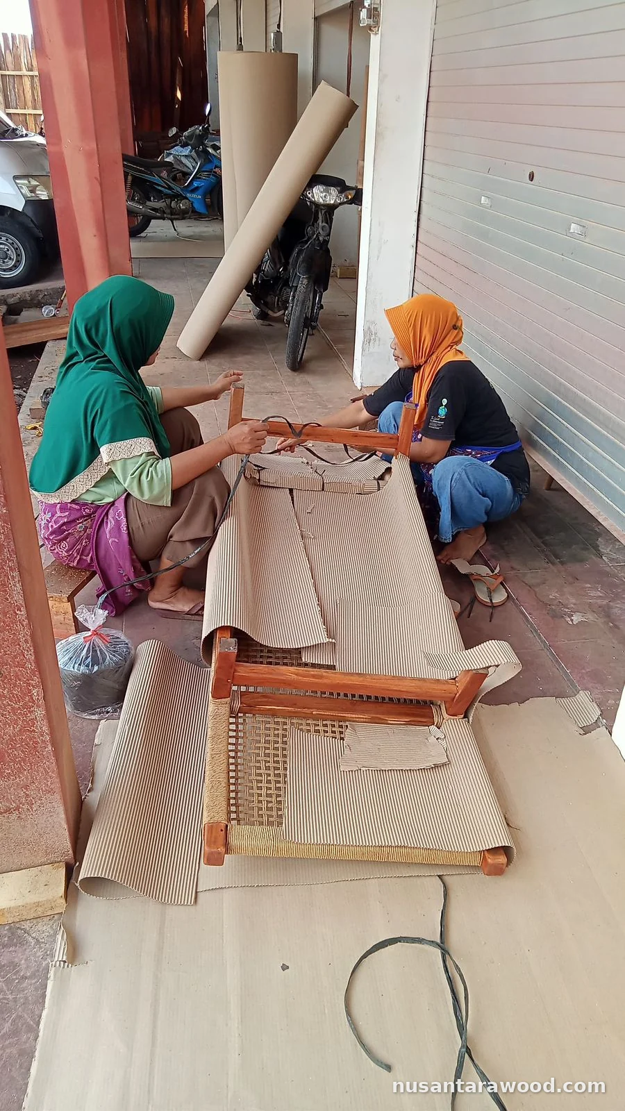 Packing a Mahogany Woven Seat Chair Workers wrapping a mahogany chair with woven seat in corrugated cardboard for export packing at Nusantara Wood