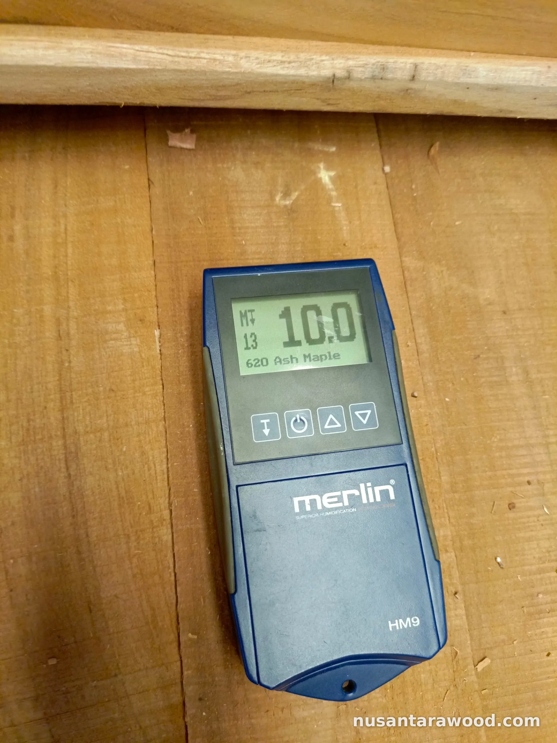 Teak Wood Moisture Content Test Moisture meter showing a 10 percent reading on teak boards during wood quality control at Nusantara Wood
